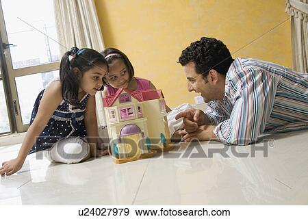 Stock Photo - Father playing with his daughters. Fotosearch