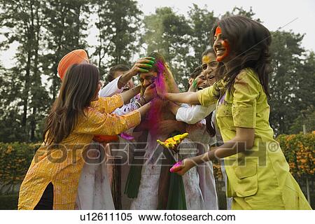 Stock Photography - Friends celebrating Holi. Fotosearch