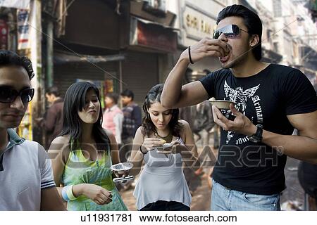 Friends enjoying street food View Large Photo Image Stock Image - Friends enjoying street food. Fotosearch