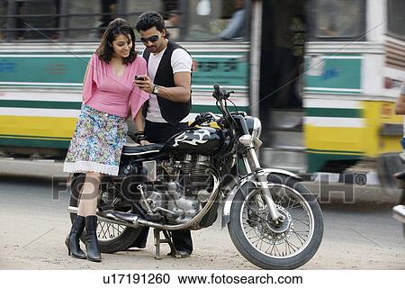 Stock Image - Friends looking at a mobile phone. Fotosearch