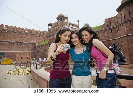 Stock Photography - Friends looking at their photograph. Fotosearch