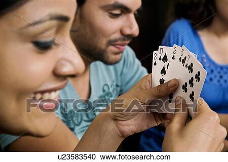 Stock Image - Friends playing cards. Fotosearch