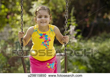 Stock Image - Girl enjoying on a swing. Fotosearch