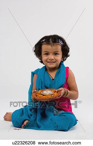 Girl holding a decorated diya View Large Photo Image Stock Photo - Girl holding a decorated diya. Fotosearch