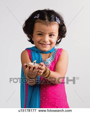 Girl holding a diya View Large Photo Image Stock Photo - Girl holding a diya. Fotosearch