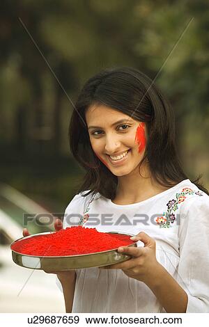 Girl holding a plate of gulal View Large Photo Image Stock Photo - Girl holding a plate of gulal. Fotosearch
