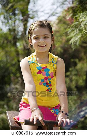 Girl sitting on a see-saw View Large Photo Image Stock Photography - Girl sitting on a see-saw. Fotosearch