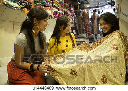 Stock Photo - Girls at a garment shop. Fotosearch