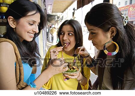 Stock Photograph - "Girls having fruit chaat, India". Fotosearch