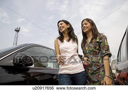 Stock Photograph - Girls next to a car. Fotosearch