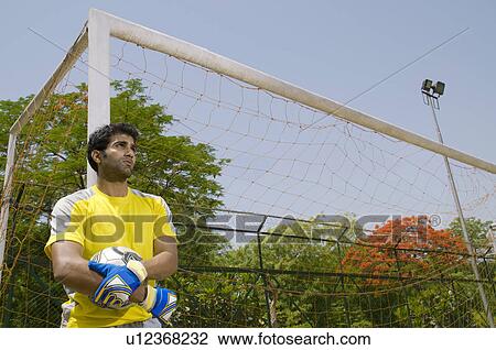 Stock Image - Goalkeeper stands next to the goal post. Fotosearch