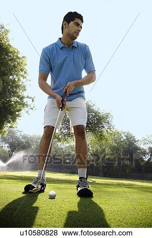 Stock Photo - Golfer about to make a strike. Fotosearch