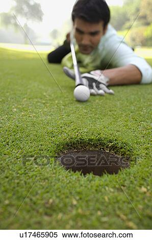 Stock Photography - Golfer putting. Fotosearch