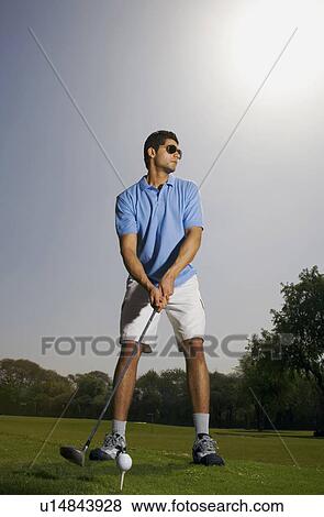 Stock Photo - Golfer tees off. Fotosearch