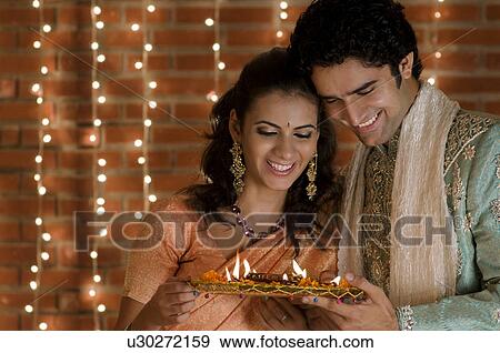 Stock Photo - Holding a tray of diyas. Fotosearch