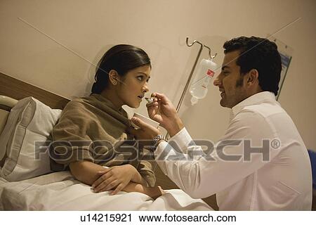 Stock Image - Husband feeds his sick wife. Fotosearch