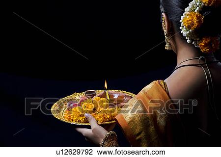 Stock Image - Indian woman performing puja. Fotosearch