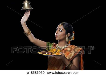 Stock Image - Indian woman performing puja. Fotosearch