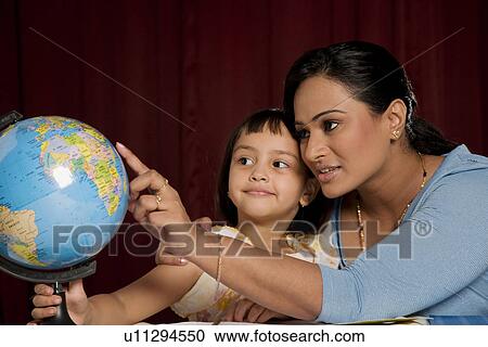 Stock Image - Looking at a globe. Fotosearch