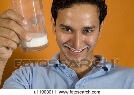 Stock Image - Man drinking a glass of milk. Fotosearch