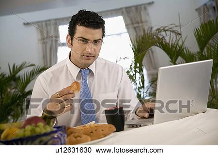 Man eating and working View Large Photo Image Stock Image - Man eating and working. Fotosearch