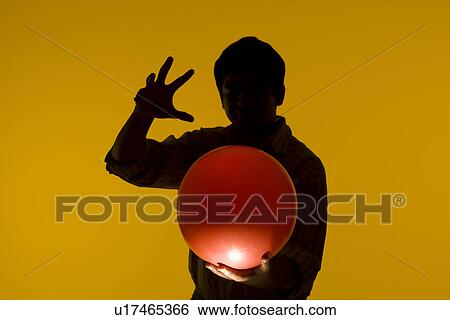 Stock Photograph - Man holding a ball. Fotosearch