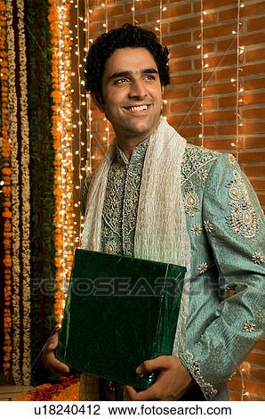 Stock Image - Man holding a gift. Fotosearch
