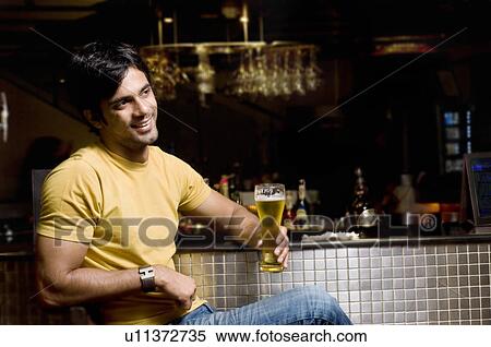 Stock Photography - Man holding a glass of beer. Fotosearch