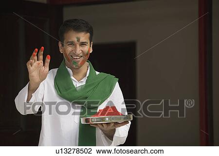 Man holding a plate of gulal View Large Photo Image Stock Image - Man holding a plate of gulal. Fotosearch