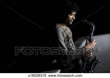 Stock Photo - Man holding a saxophone. Fotosearch