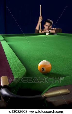 Stock Photo - Man looking at billiard ball. Fotosearch