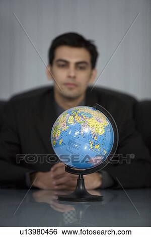 Man looking at the globe View Large Photo Image Stock Photograph - Man looking at the globe. Fotosearch