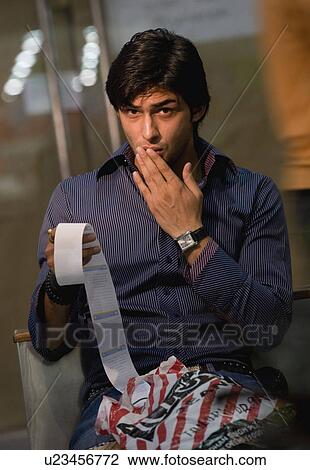 Stock Image - Man reacts to shopping bill. Fotosearch