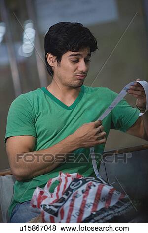 Stock Photo - Man reacts to shopping bill. Fotosearch