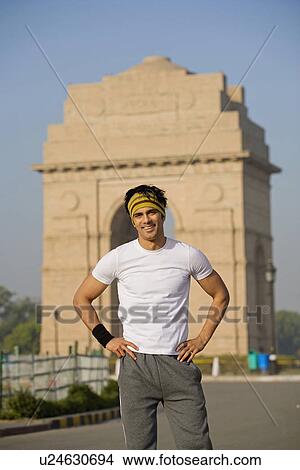 Picture - Man standing in front of the India Gate. Fotosearch