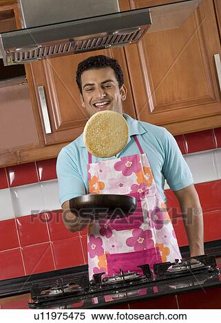 Stock Photography - Man tossing a pancake. Fotosearch