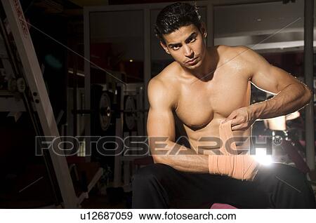 Stock Photo - Man tying a bandage. Fotosearch