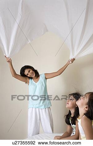 Stock Image - Mother playing with her daughters. Fotosearch