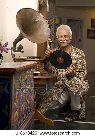 Stock Photograph - Old man holding a record. Fotosearch
