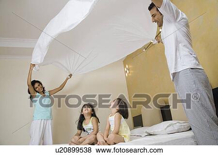 Stock Photo - Parents playing with their daughters. Fotosearch