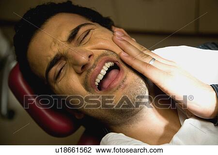 Stock Image - Patient with a toothache. Fotosearch