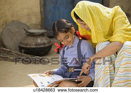 Stock Image - Rural mother reading with her daughter. Fotosearch