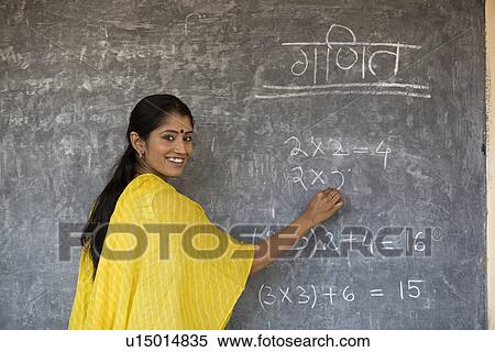 Stock Photography - Rural teacher writing on the board. Fotosearch