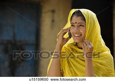 Rural woman talking on a mobile View Large Photo Image Stock Image - Rural woman talking on a mobile. Fotosearch