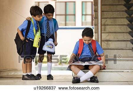 School boy looking at a book View Large Photo Image Stock Photo - School boy looking at a book. Fotosearch