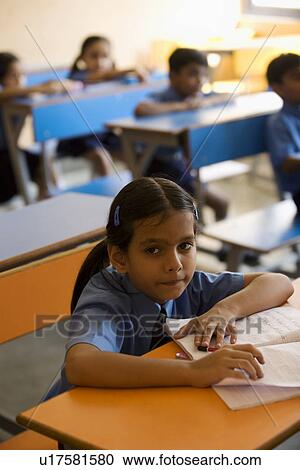 Stock Image - School girl at her desk. Fotosearch