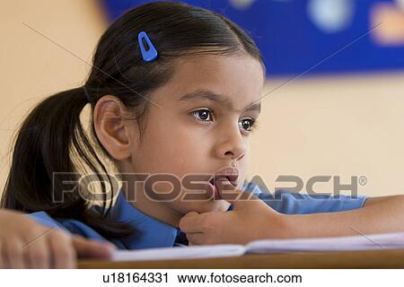 Stock Image - School girl at her desk. Fotosearch