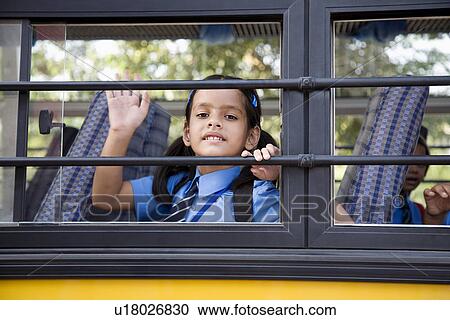Stock Image - School girl sitting in a school bus. Fotosearch