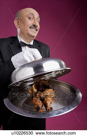 Stock Image - Serving chicken in a platter. Fotosearch