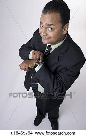 Picture - Showing his watch. Fotosearch